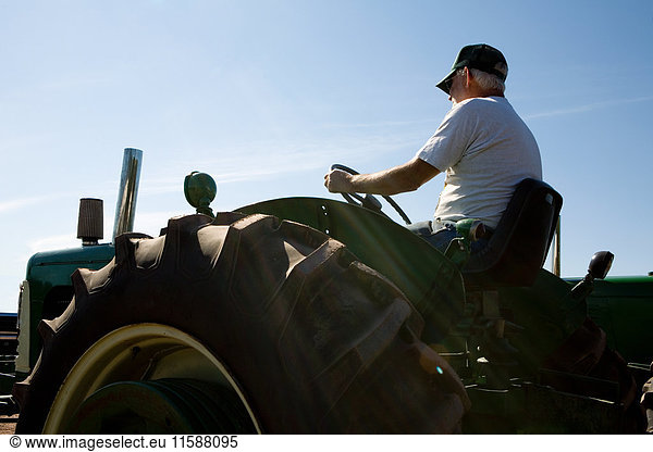 Traktor fahrender Senior-Landwirt