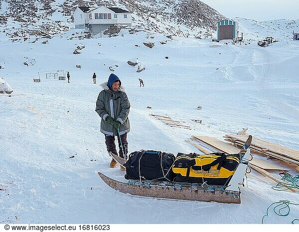 Transport des Gepäcks mit dem Schlitten. Das traditionelle und abgelegene grönländische Inuit-Dorf Kullorsuaq  Melville Bay  Teil der Baffin Bay. Amerika  Nordamerika  Grönland  dänisches Gebiet.