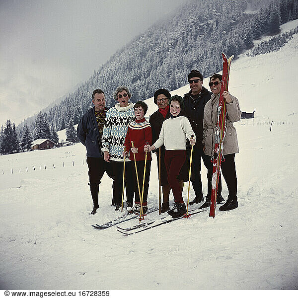 Travel and Leisure:
Winter holidays. Group photo with two couples and their daughters on a skiing holiday in the mountains. Amateur photo  Germany  no date (1960s).
