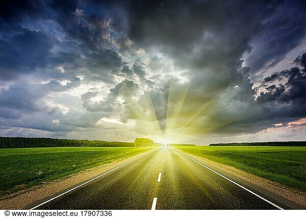 Travel concept background  road and stormy dramatic sky on sunset