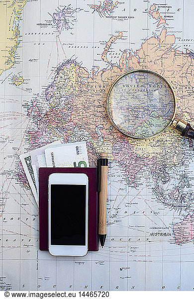 Travel planning with a world map  money  cell phone and magnifying glass
