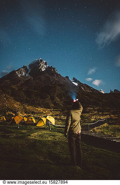 Traveler looking at starry sky in mountains