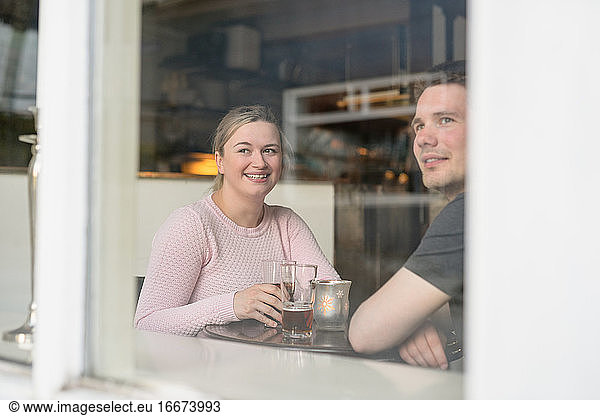 Travelling couple enjoying hot tea in cafe