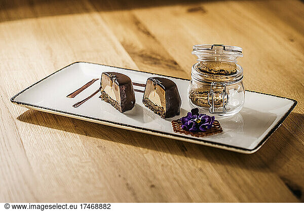 Tray with halved chocolate cake and jar of macaroon cookies