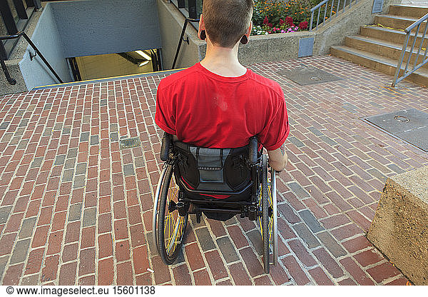 Trendy Mann mit einer Rückenmarksverletzung im Rollstuhl plant seinen Zugang zur U-Bahn