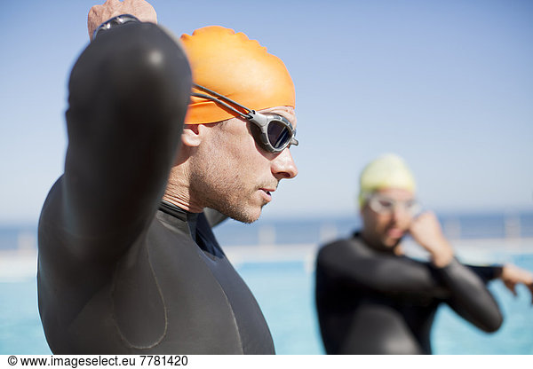 Triathlete tying on goggles outdoors