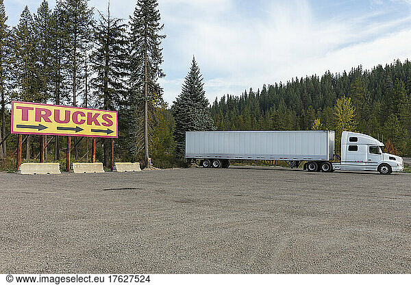 TRUCKS billboard sign and large parked semi truck.