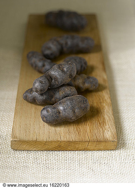 Truffle de Chine blue-violet potatoes on chopping board