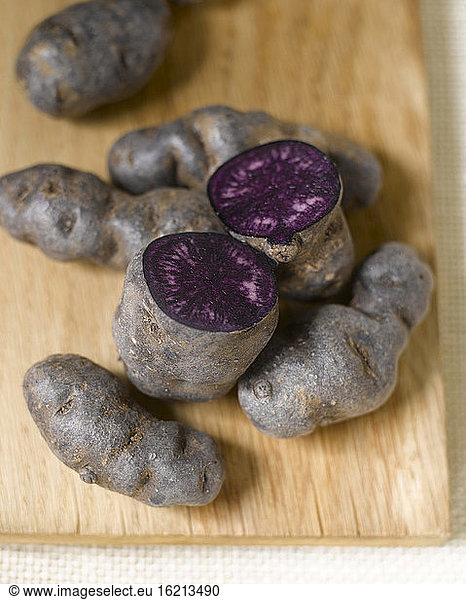 Truffle de Chine blue-violet potatoes on chopping board  elevated view