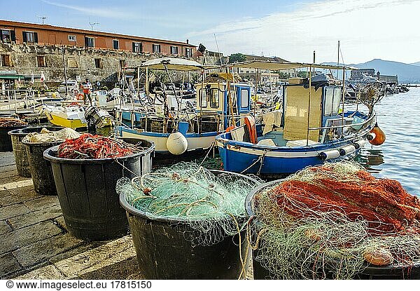 Tubs with red and green fishing nets  behind them local small fishing boats moored to quay of old harbour of Portoferraio  Portoferraio  Elba  Tuscany  Italy  Europe