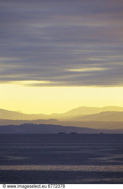 Tugboat and Vancouver Island at sunset,  view from Sunshine Coast,  British Columbia