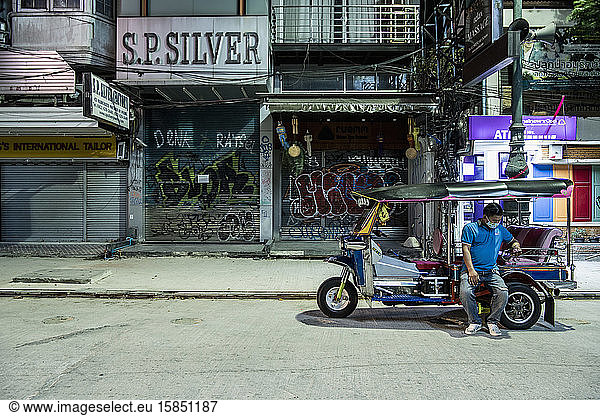 Tuk Tuk driver at deserted Khaosan Road in Bangkok during Covid 19
