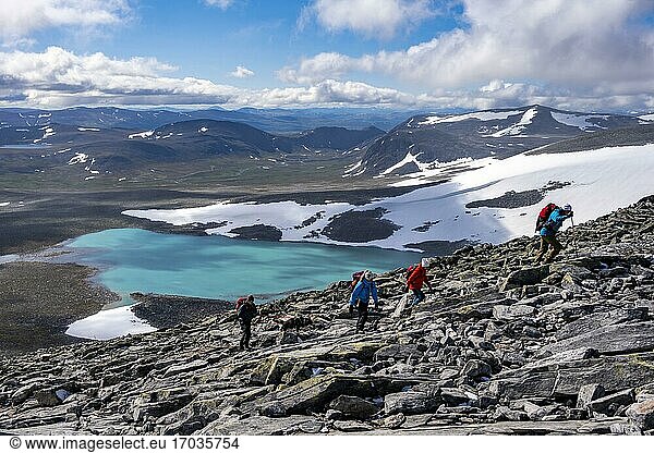 Tundra  barren mountain landscape with mountain lake  Hiker on hike to Snøhetta mountain  Dovrefjell National Park  Oppdal  Norway  Europe