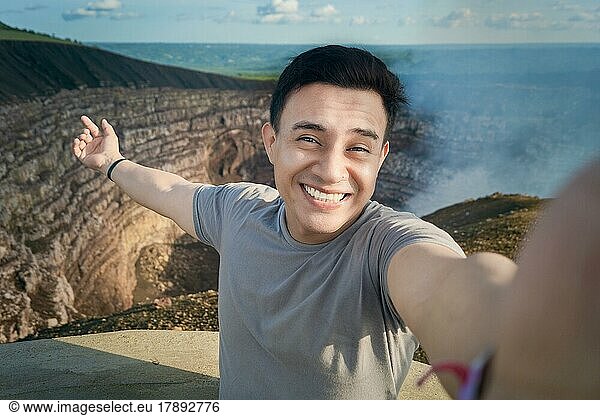 Turista haciéndose un selfie en un mirador. Guapo turista tomando un selfie de vacaciones. Hombre aventurero haciéndose un selfie en un mirador. Primer plano de la persona que toma un selfie de aventura. Volcán Masaya  Nicaragua  Central America