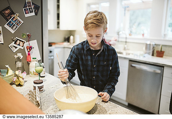 Tween boy baking in kitchen