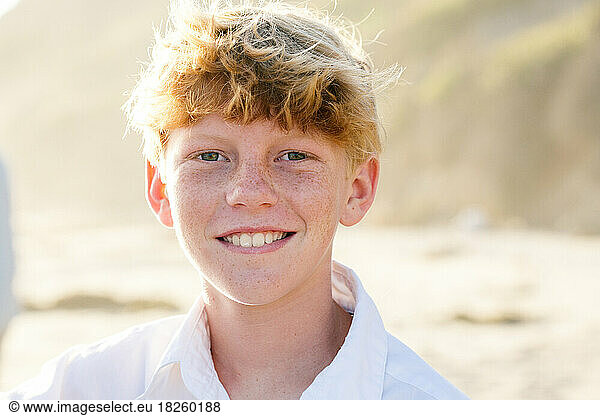 Tween Boy With Red Hair And Freckles Smiles At The Beach