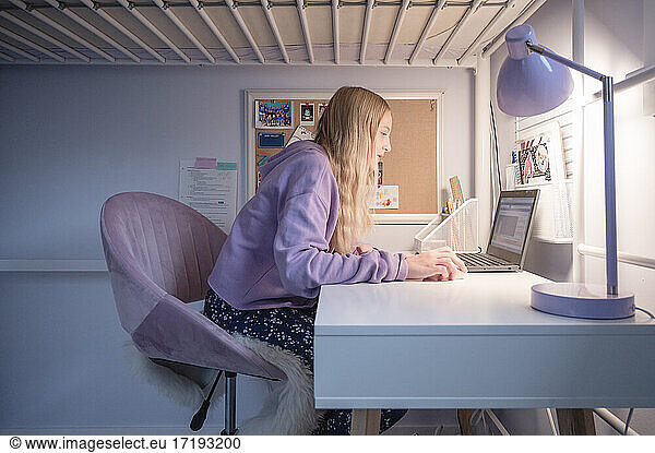 Tween Girl Sitting at Desk at Home Attending Remote School