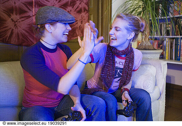 Twenty-year-old women play video games in their apartment.