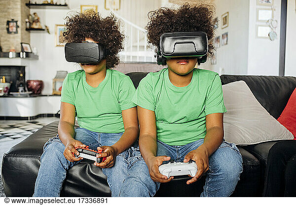 Twin brothers playing game wearing Virtual reality glasses at home