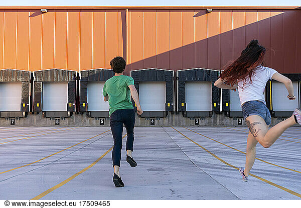 Two acrobats running during training  rear view