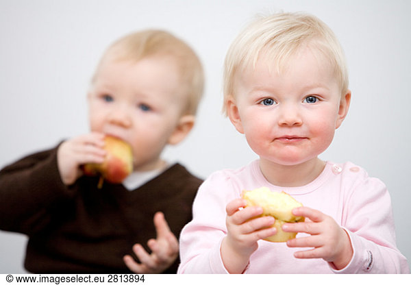 Two babies holding apples Sweden.