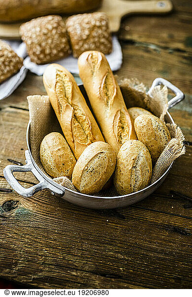 Two baguettes and four rye bread rolls in a pot