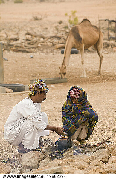 Two bedouin men boil water on a campfire in the Jabal Samhan  Oman.