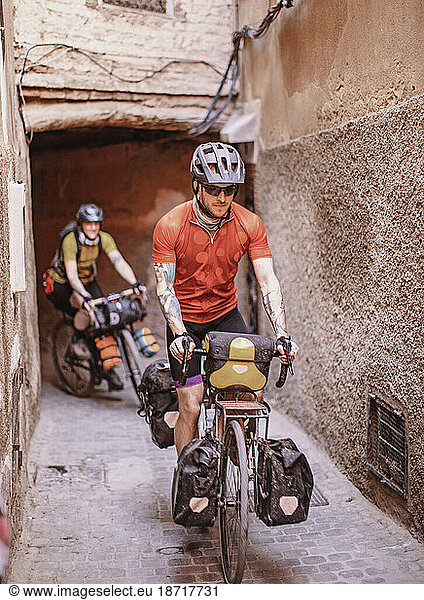 two bike packers ride through the narrow streets of marrakesh  Morocco