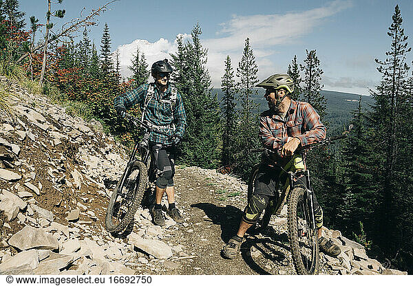 Two bikers take a break on the trail at the Timberline Bike park in OR