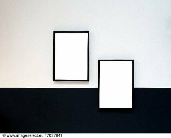 Two blank Poster canvas frame hanging on black and white wall interior design modern mock up frames copy space .