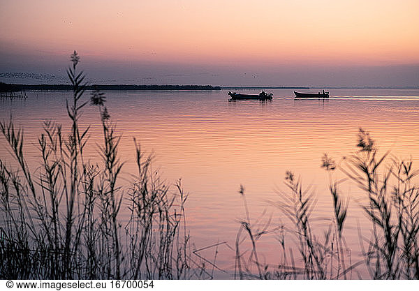 Two boats at Valencia's Albufera sunset against the light