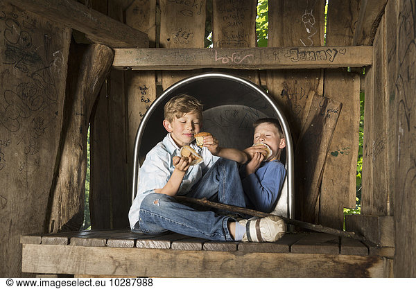 Two boys eating muffins in playground  Munich  Bavaria  Germany