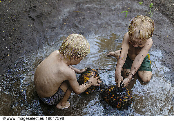 Two boys playing in mud  Nusa Penida  Bali  Indonesia