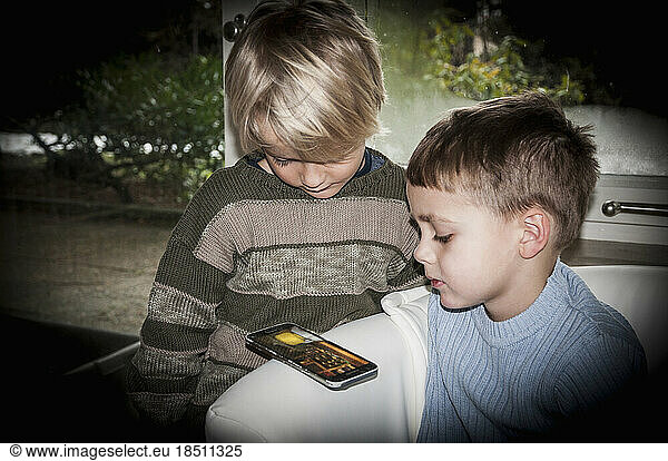 Two boys using smart phone at home