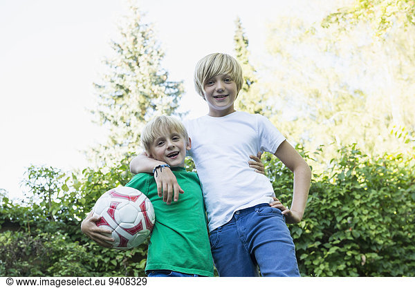 Two brothers arm in arm in the garden