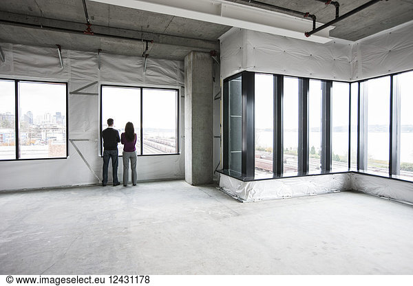 Two business owners standing in their new empty raw business space.