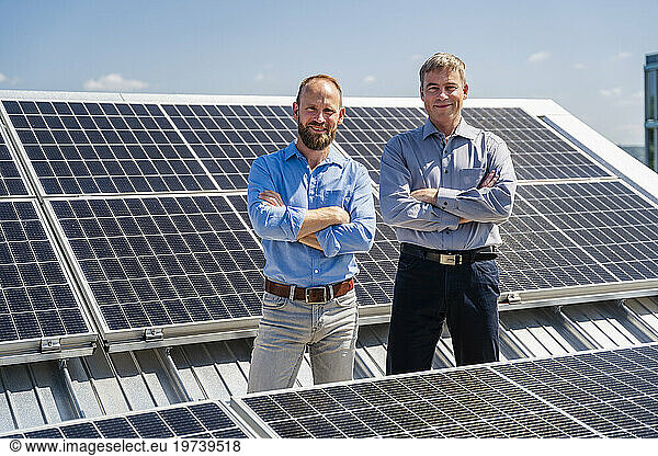 Two businessmen exude confidence as they stand among rows of solar panels  ready to harness the power of the sun.