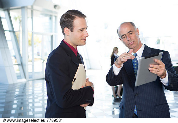 Two businessmen using digital tablet