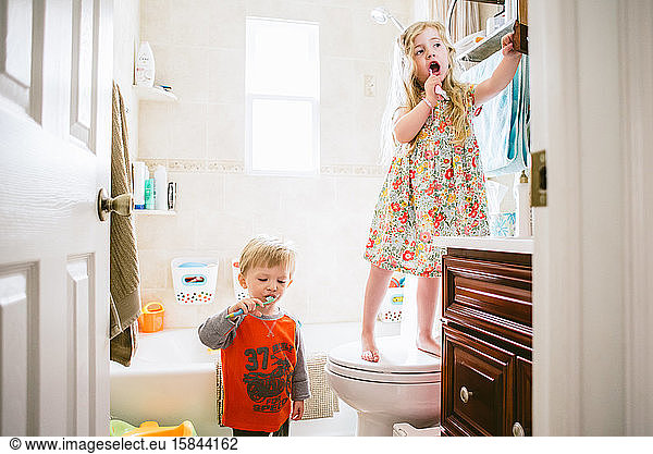 Two children brush their teeth.