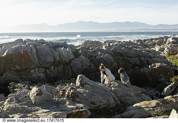 Two children exploring the jagged rocks and rock pools
