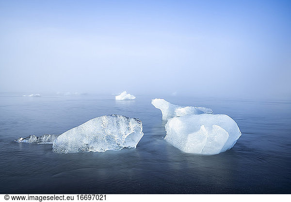 Two chunks of ice on sea shore at Diamond beach near Jokulsarlon Glacier Lagoon in foggy weather  Iceland