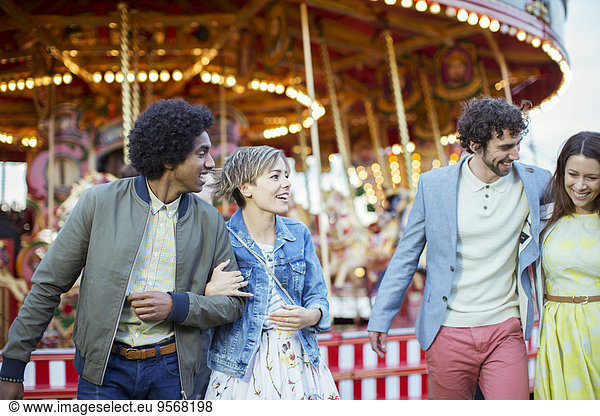 Two couples walking in amusement park and laughing