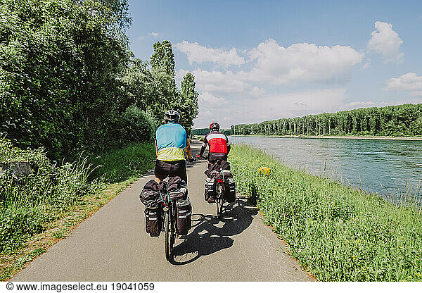 Two cyclists riding his bikes near to Rin River  Germany