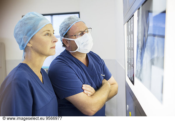 Two doctors discussing patient's x-ray and MRI before surgery