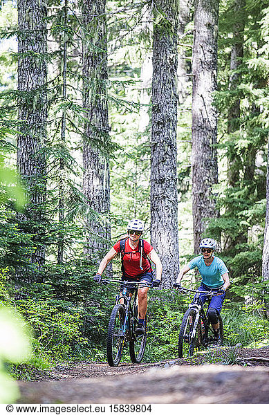 Two female bikers enjoy a trail in Sandy  OR near Mt. Hood.