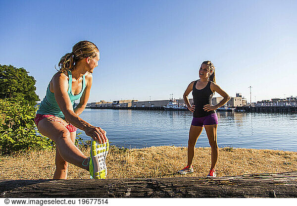Two female runners stretching near Puget Sound  Seattle  Washington State  USA
