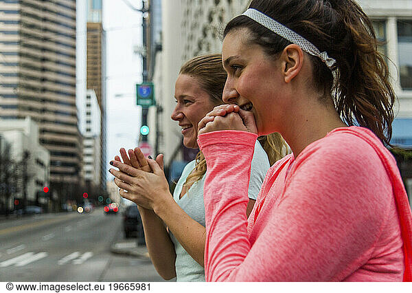 Two female runners warming hands in downtown Seattle  Washington State  USA
