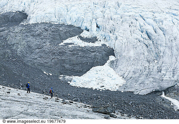 Two figures descend the tongue of the Storbreen Glacier near Norway's Jotunheimen National Park.