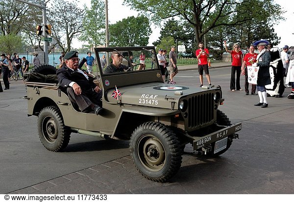 Two former military men drive in a restored jeep at the end of a city sponsored parade to honour the local team for winning the national junior hockey championship.