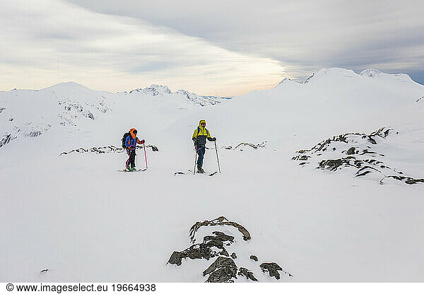 two friends ski touring in rugged mountain terrain